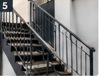Ilustracja wygenerowana przez AI: stalowa balustrada przy biegu schodów w jasnym wnętrzu. Nie jest zdjęciem realizacji MSW.